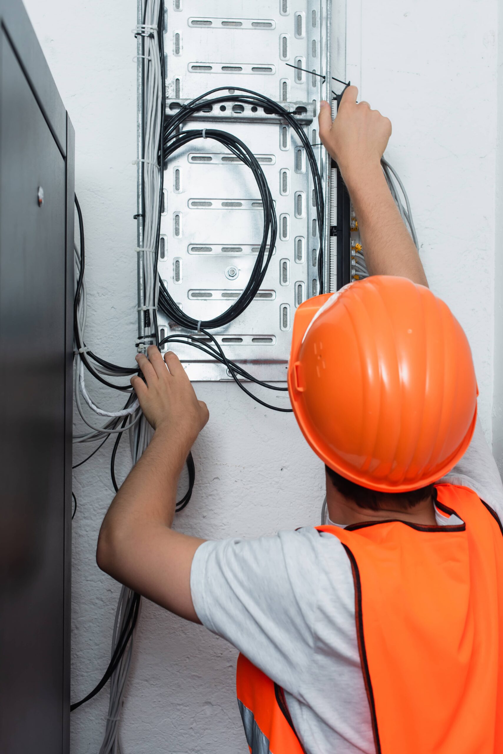 back view of workman standing near switchboard
