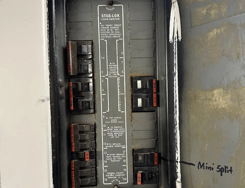 Older breaker panel with a hand-written circuit directory inside the door in a Phoenix-area home