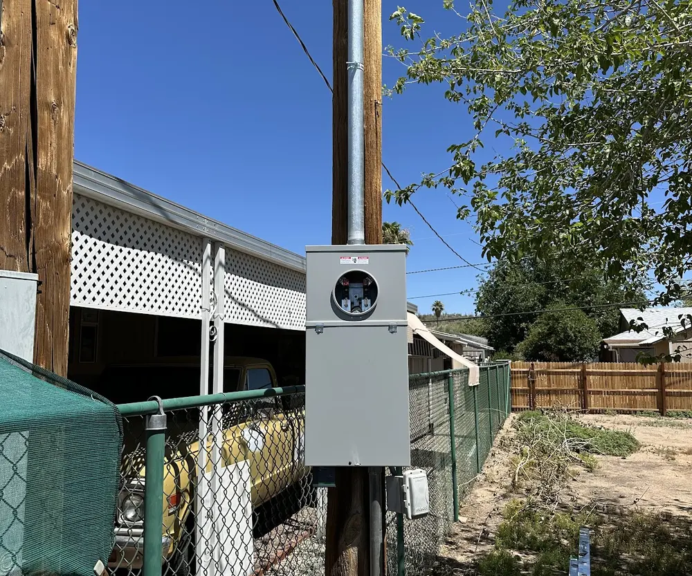 New outdoor meter socket and service panel mounted on a utility pole, ready for power to be reconnected after a panel upgrade