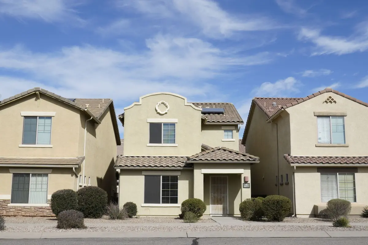 Two-story stucco homes with clay tile roofs and desert landscaping on a Phoenix-area street
