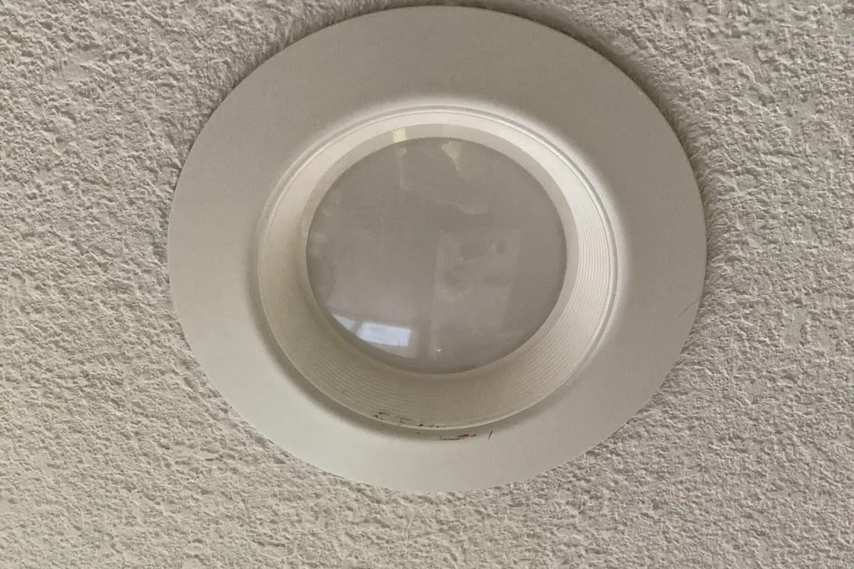 Round ceiling fixture with a frosted lens on a textured ceiling